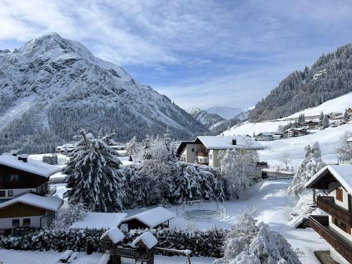 a village covered in snow with mountains in the background at Appartement 412 Kunners Oostenrijk in Mittelberg