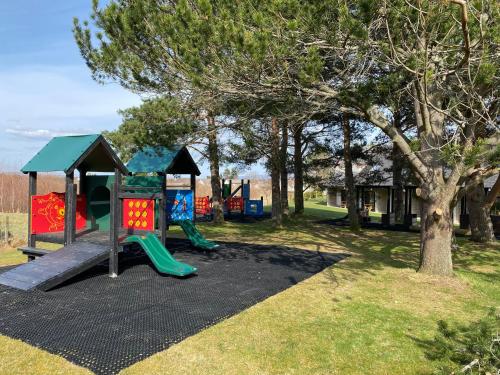 a playground with two slides and a play structure at Scandinavian Village Ltd in Aviemore