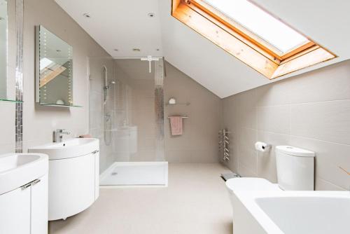 a bathroom with a sink and a skylight at Shalom - holiday home with panoramic views of the sea in Kingsdown