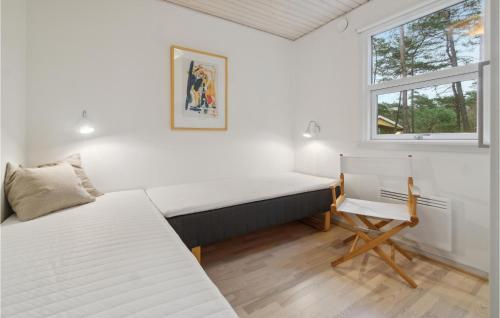 a bedroom with two beds and a desk and a window at Stunning Home In Nex With Kitchen in Vester Sømarken