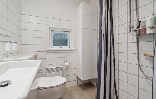 uma casa de banho branca com um WC e um lavatório em Stunning Home In Nex With Kitchen em Vester Sømarken