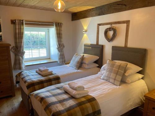 a bedroom with two beds with towels on them at Bedlwyncoch Farmhouse in Brecon