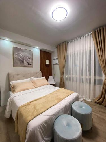a bedroom with a large bed and a large window at Jeiden Suites Bacolod in Bacolod