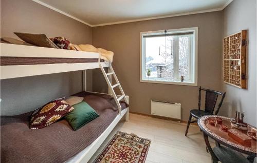 1 Schlafzimmer mit 2 Etagenbetten und einem Tisch in der Unterkunft Cozy Apartment In Sjusjen With Kitchen in Sjusjøen
