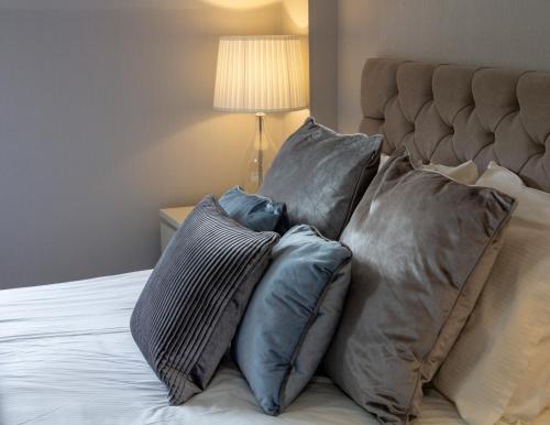 a pile of pillows sitting on top of a bed at Scandinavian Village Ltd in Aviemore