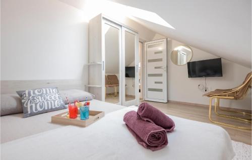 a bedroom with a large white bed with towels on it at Awesome Home In Mijaca With Kitchen 