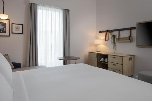 a bedroom with a bed and a dresser and a television at Hilton Garden Inn Stoke On Trent in Stoke on Trent