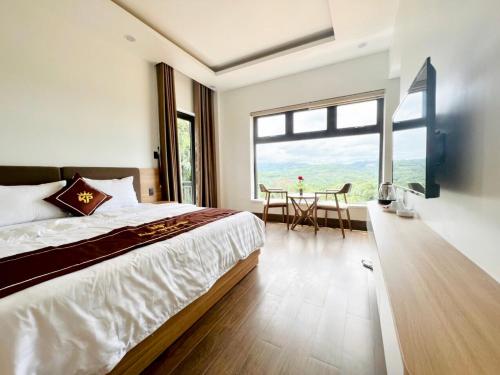 a bedroom with a large bed and a table at Khánh Phương Luxury in Châu Làng Chánh