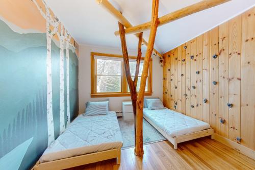 2 camas en una habitación con paredes de madera en Woodland Cottage In the Mountains, 