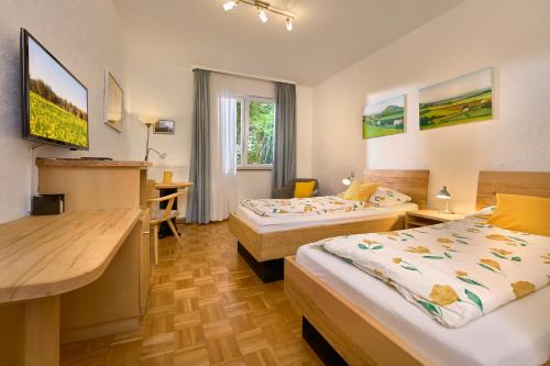 a hotel room with two beds and a desk at Hotel-Bio Gasthaus Am Felsenkeller in Staufen im Breisgau