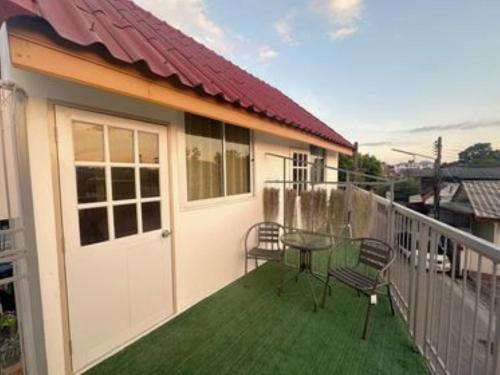 a balcony of a house with a table and chairs at NooN23 Hostel in Chiang Mai