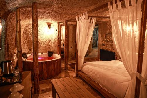 ein Schlafzimmer mit einem Bett und einer Badewanne. in der Unterkunft Matiana View Cave Hotel in Goreme