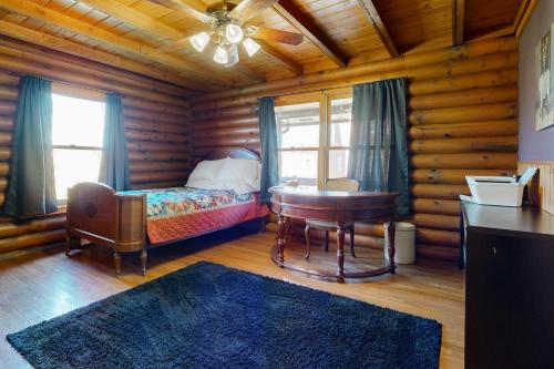 1 dormitorio con cama, escritorio y mesa en Hager Cabin 