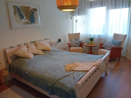 a bedroom with a large bed and two chairs at Oudaen 36 in Lelystad