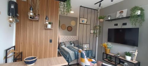 a living room with a couch and a flat screen tv at Hope Aparta Lofts in Salento