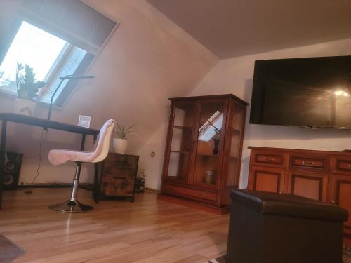 sala de estar con silla y TV grande en Ferienwohnung am neuen Teich en Lübz