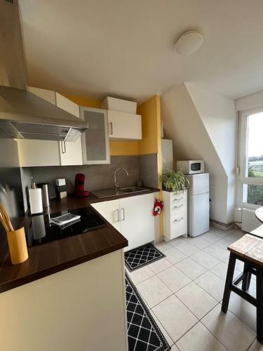 une cuisine avec des armoires blanches et un comptoir dans l'établissement Le nid des Pruniers - F2 au calme - parking privé, à Sélestat