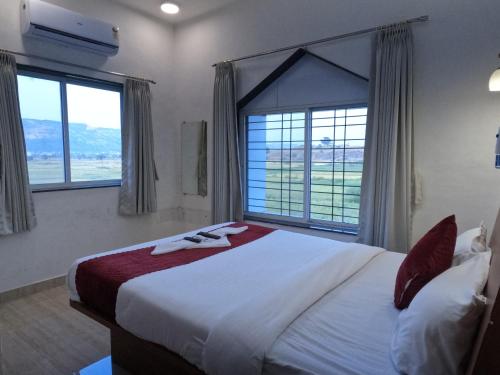 a bedroom with a large bed with a large window at Hotel Sandesh Palace Lonavala in Lonavala