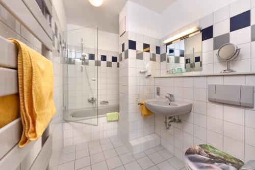 a white bathroom with a sink and a shower at Hotel-Bio Gasthaus Am Felsenkeller in Staufen im Breisgau