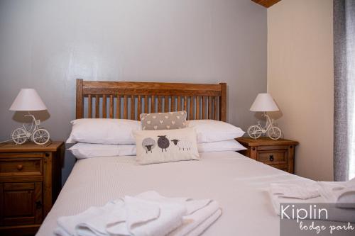 a bedroom with two beds with white sheets and two lamps at Surrey Lodge in Richmond