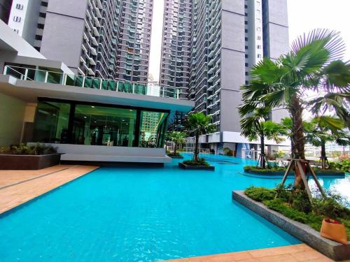 a large blue pool in a building with tall buildings at Maxim Majestic 3BR Connaught MRT in Kuala Lumpur