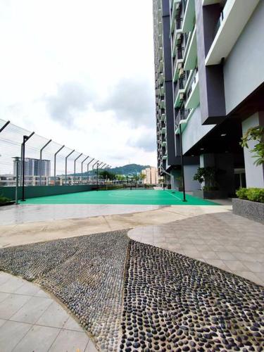 a large building with a green courtyard in front of it at Maxim Majestic 3BR Connaught MRT in Kuala Lumpur