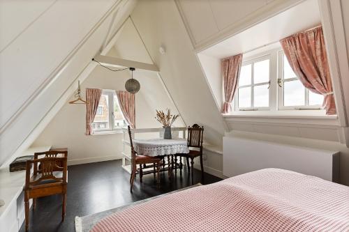 a bedroom with a bed and a table and chairs at Boutique Hotel Jongwijs Westzaan in Westzaan