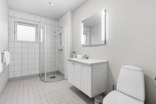 a white bathroom with a sink and a toilet at Downtown Apartment - THE VIEW in Tromsø