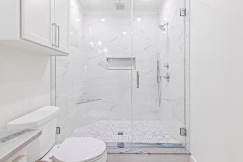a white bathroom with a shower and a toilet at The Boating, Fishing, and Gaming Retreat in Hackberry