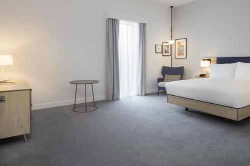 a hotel room with a bed and a table at Hilton Garden Inn Stoke On Trent in Stoke on Trent