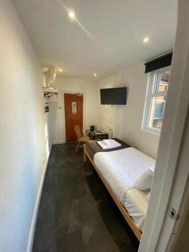 a small bedroom with a bed and a table at Lady Hamilton Inn in Portsmouth