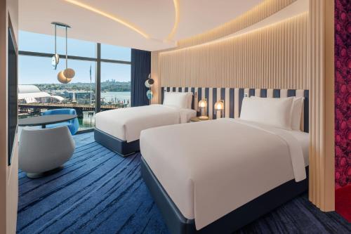 um quarto de hotel com duas camas e uma mesa em W Sydney em Sydney