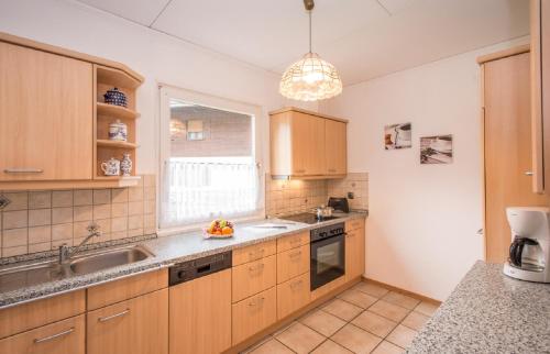 グライナウにあるKomfort-Ferienhaus Alpspitzのキッチン(木製キャビネット、シンク、窓付)