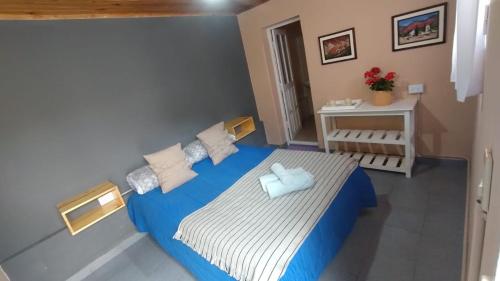 a small bedroom with a blue and white bed at La Puerta Verde in Humahuaca