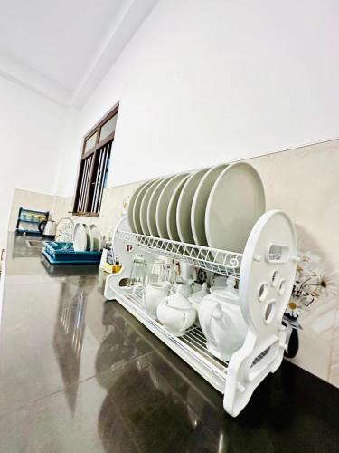 a dish drying rack with dishes and a toilet at Eden Villa - Ahangama in Ahangama