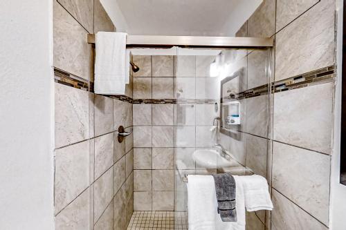 La salle de bains est pourvue d'un lavabo, d'une douche et de serviettes. dans l'établissement Heart of Houston Getaway, à Houston