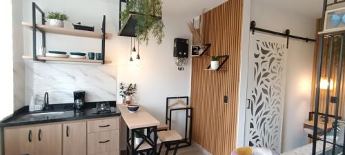 uma cozinha com um lavatório e uma mesa num quarto em MINI LOFT MODERNO Y ACOGEDOR em Salento