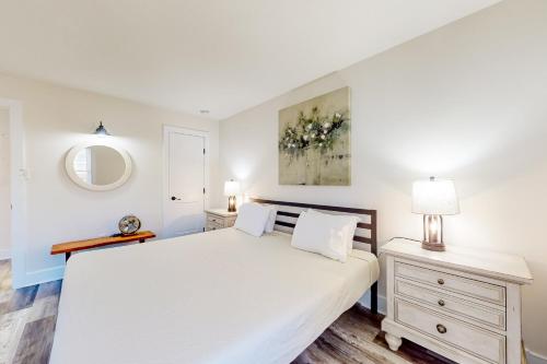 a white bedroom with a bed and a mirror at Town of Rehoboth Beach --- 20485 Lincoln St. Unit 2 in Rehoboth Beach
