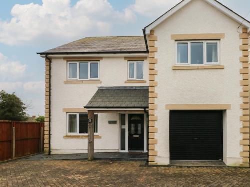 a detached house with a garage at Llygad Yr Haul Sun in Burry Port