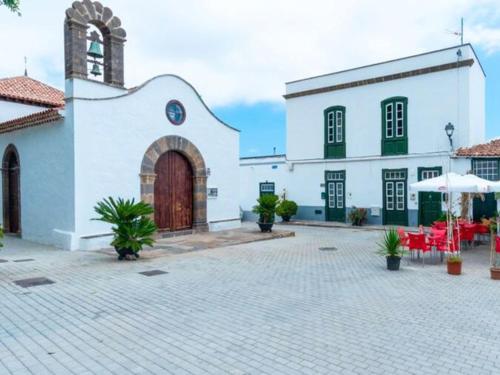 a large white building with a large door and a courtyard at Live Arico Casa Abuela in Arico el Nuevo
