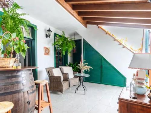 un patio con una puerta verde y sillas en Live Arico Casa Abuela, en Arico el Nuevo