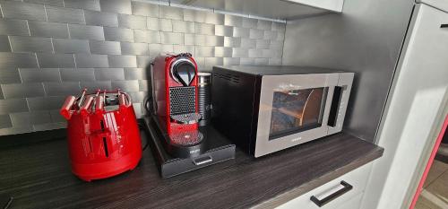a kitchen with a microwave and a red appliance on a counter at Milan Condo ideal for Families,Pets,Business in Milan