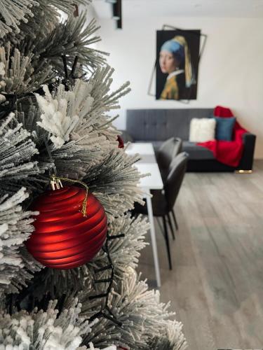 a red ornament on a christmas tree in a living room at 7 SKY UDINE in Udine