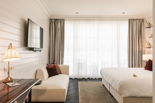 a hotel room with a bed and a couch at De Lindenhoeve Boutique Hotel in Sluis