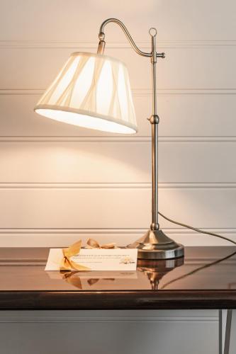 a lamp sitting on a table with a book at De Lindenhoeve Boutique Hotel in Sluis