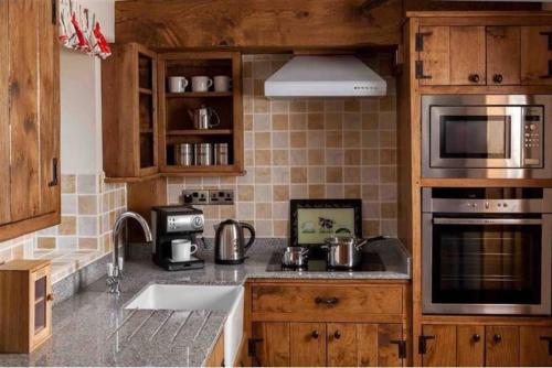 uma cozinha com um lavatório e um fogão forno superior em Trefaen Cottage em Brecon