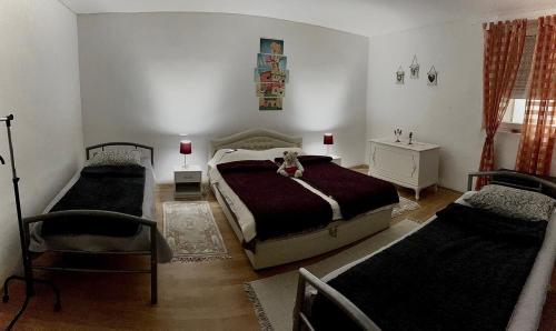 a bedroom with two beds and a chair in it at BOJANA12 in Bačka Palanka