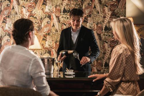 a man in a tuxedo standing in front of a woman at De Lindenhoeve Boutique Hotel in Sluis