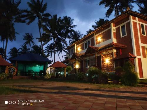 a house at night with lights on at Glucklich Beach Cottages in Kundapur