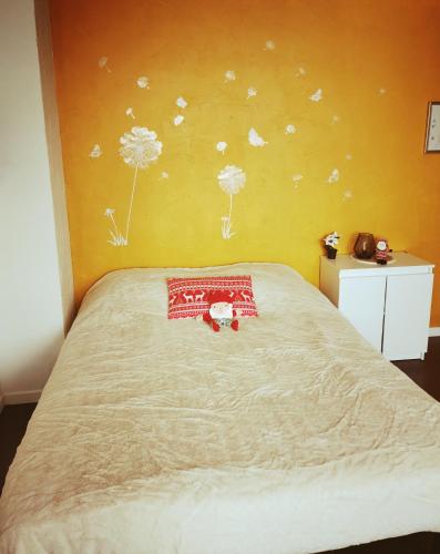 a bedroom with a bed with dandelions on the wall at Cozy Studio Strasbourg in Strasbourg